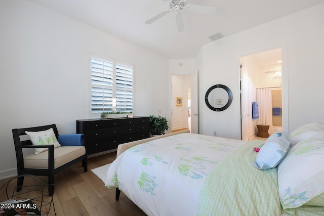 bedroom featuring hardwood / wood-style floors, ceiling fan, and ensuite bath