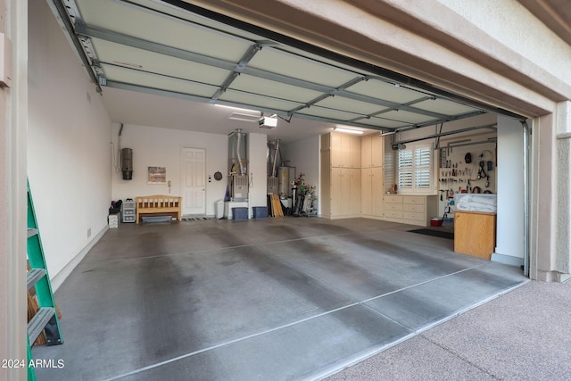 garage with a workshop area, heating unit, a garage door opener, and water heater