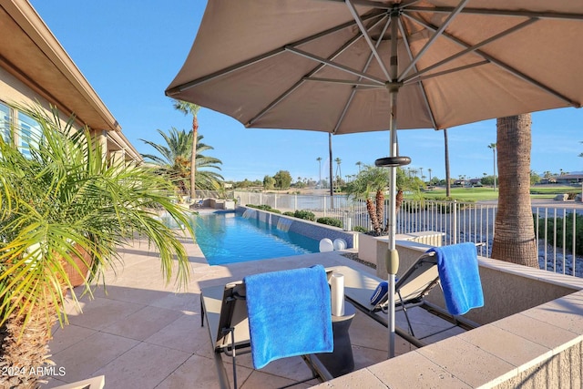 view of pool with a patio area and a water view