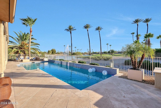 view of pool with a water view and a patio area