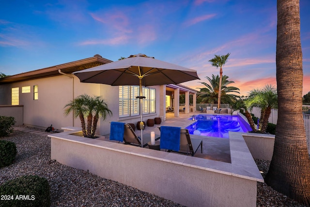 pool at dusk with a patio