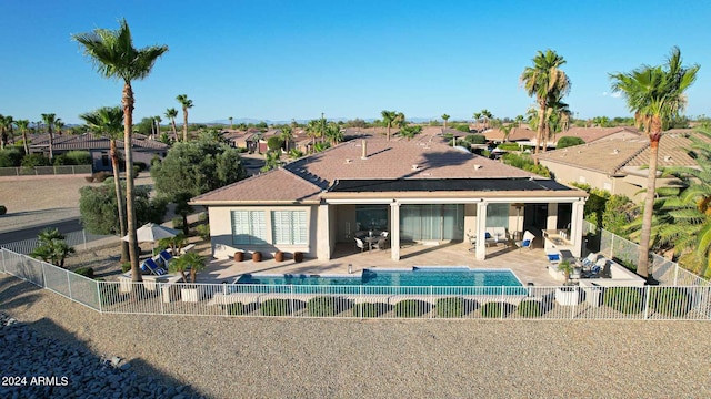 back of house with a fenced in pool, a patio area, and an outdoor hangout area