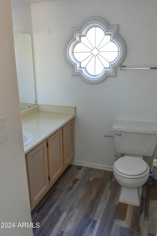 bathroom with wood-type flooring, vanity, and toilet