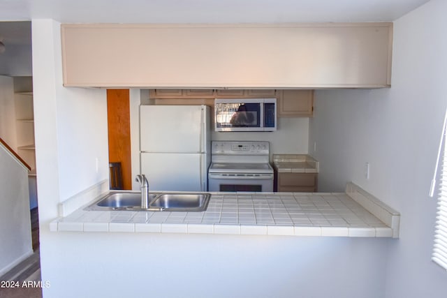 kitchen featuring white appliances, tile countertops, and sink