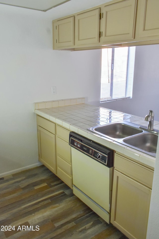 kitchen featuring cream cabinets, white dishwasher, sink, dark hardwood / wood-style floors, and kitchen peninsula