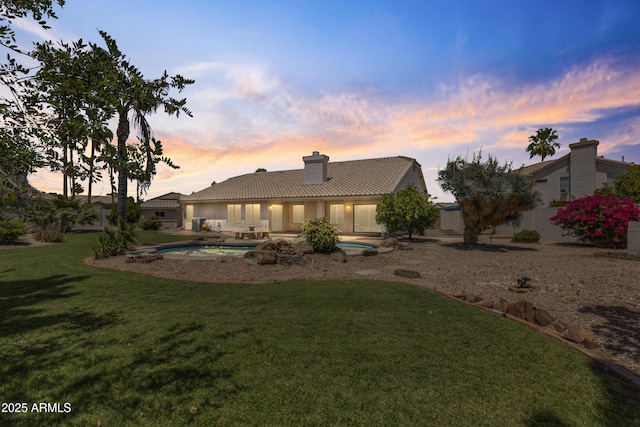 19010 N 35th Way, Phoenix, AZ 85050 - back of house at dusk featuring a chimney, a tile roof, an outdoor pool, a yard, and a patio