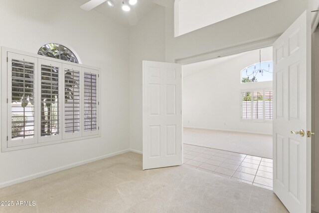 19010 N 35th Way, Phoenix, AZ 85050 - carpeted empty room featuring a chandelier, a ceiling fan, high vaulted ceiling, tile patterned floors, and baseboards