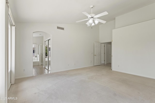 19010 N 35th Way, Phoenix, AZ 85050 - empty room with arched walkways, light carpet, a ceiling fan, baseboards, and a high ceiling
