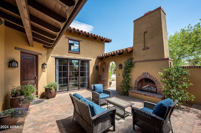 view of patio with an outdoor living space with a fireplace