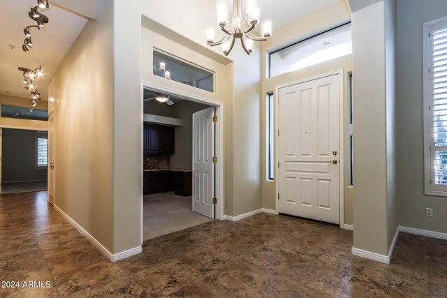 kitchen with sink, a high ceiling, decorative light fixtures, white appliances, and a center island with sink