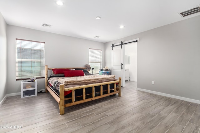 bedroom featuring multiple windows and a barn door