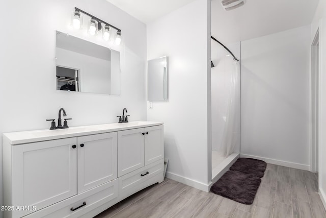 bathroom with vanity, hardwood / wood-style floors, and walk in shower