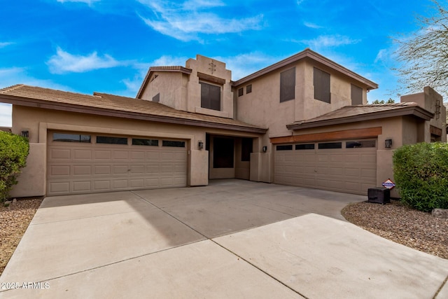 view of front of property featuring stucco siding, an attached garage, and driveway