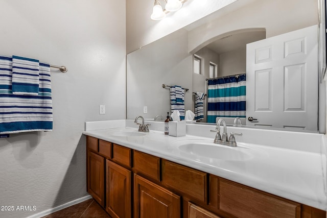 full bathroom featuring double vanity, tile patterned flooring, and a sink