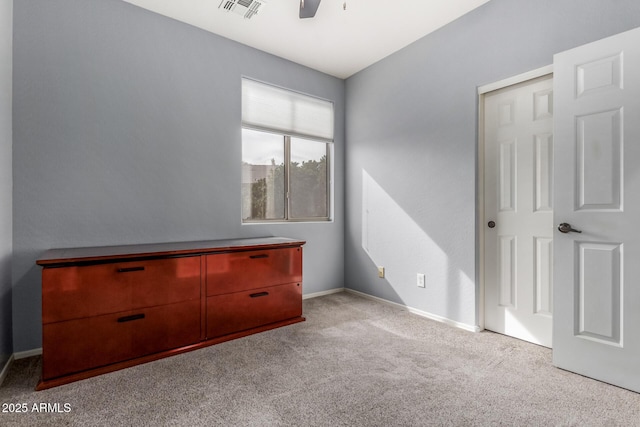 unfurnished bedroom featuring light carpet, ceiling fan, visible vents, and baseboards