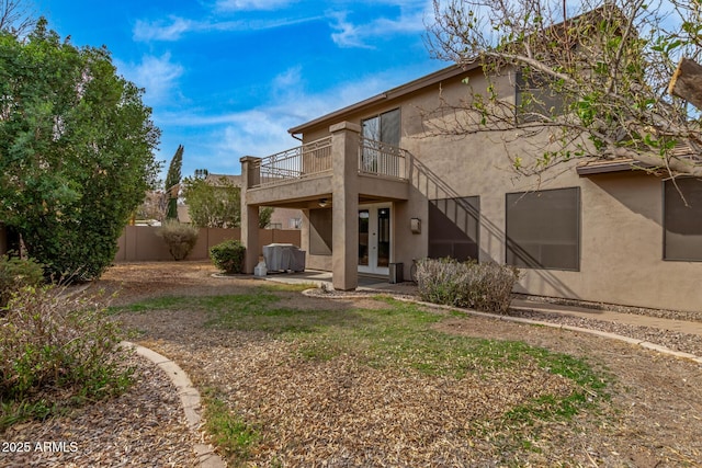 back of property featuring a balcony, fence, french doors, stucco siding, and a patio area