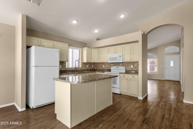 kitchen with decorative backsplash, arched walkways, a sink, lofted ceiling, and white appliances