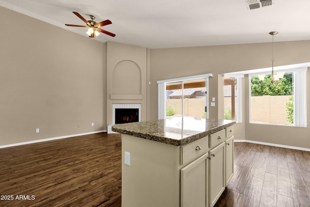 kitchen featuring visible vents, a center island, vaulted ceiling, dark wood-style floors, and open floor plan