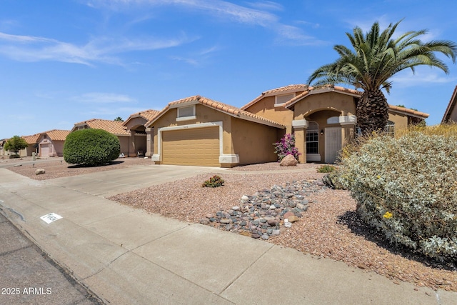 view of front of house with a garage, stucco siding, concrete driveway, and a tiled roof
