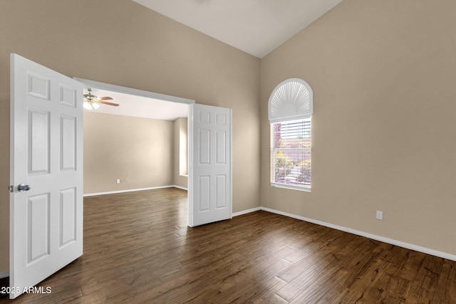 unfurnished room with dark wood-type flooring, a ceiling fan, baseboards, and high vaulted ceiling