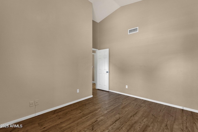 spare room featuring baseboards, visible vents, high vaulted ceiling, and dark wood-type flooring