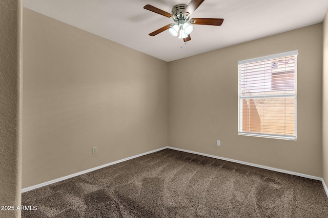 carpeted spare room with baseboards and a ceiling fan