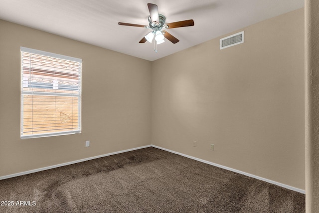 unfurnished room with ceiling fan, visible vents, baseboards, and carpet