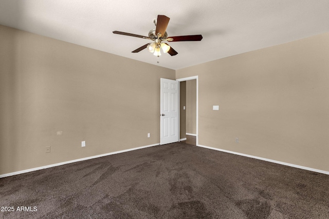 spare room with baseboards, a ceiling fan, and dark colored carpet