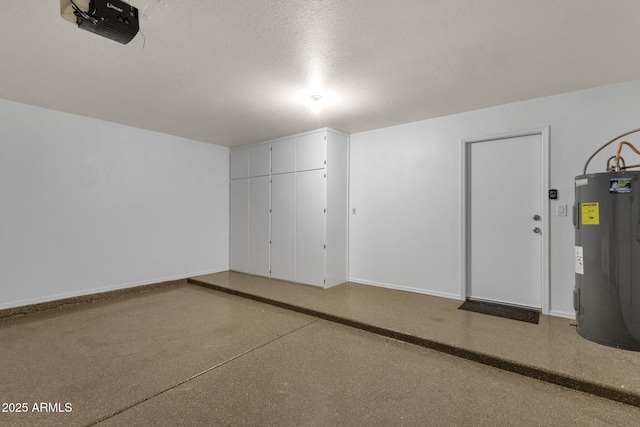 garage featuring baseboards and electric water heater