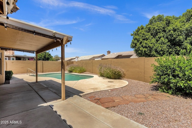 view of pool with a fenced backyard and a patio