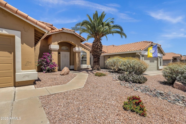 mediterranean / spanish-style house with stucco siding and a tile roof