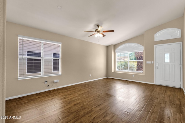interior space with a ceiling fan, baseboards, wood finished floors, and lofted ceiling