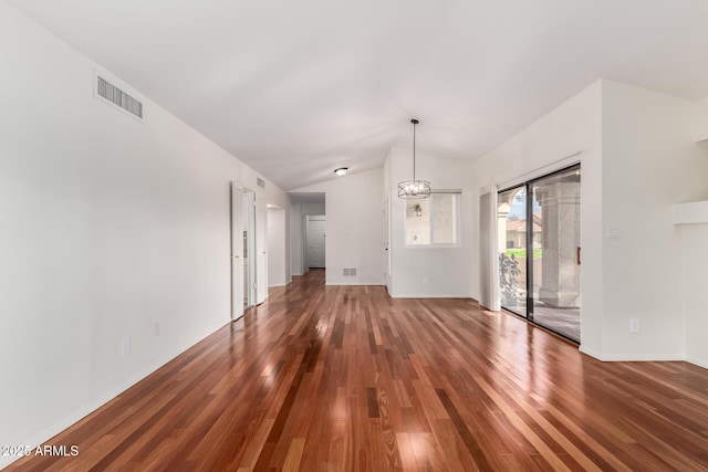 interior space featuring lofted ceiling, an inviting chandelier, visible vents, and wood finished floors