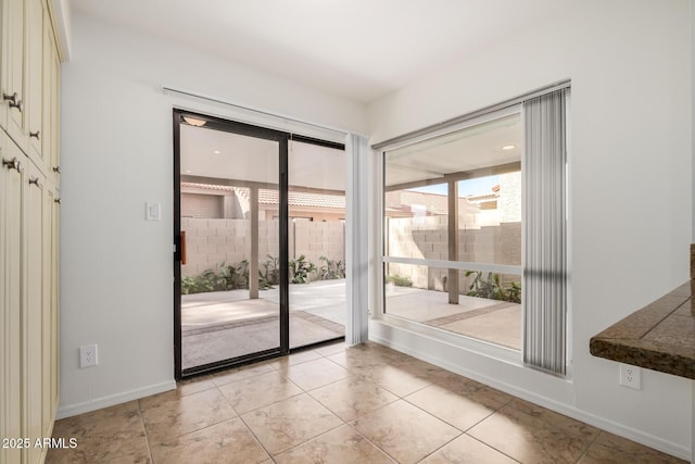 doorway to outside featuring baseboards and light tile patterned floors