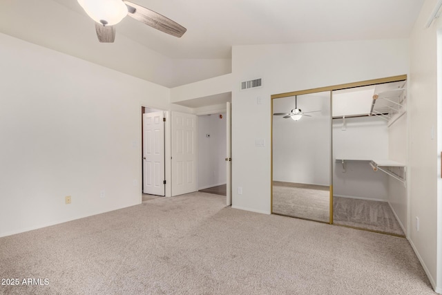 unfurnished bedroom with lofted ceiling, carpet floors, visible vents, a ceiling fan, and a closet