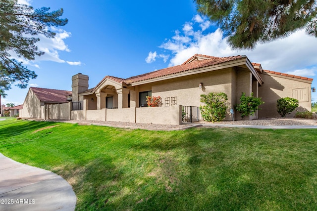 exterior space with a yard, a tiled roof, fence, and stucco siding