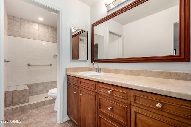 full bath featuring toilet, tile patterned flooring, a tile shower, and vanity