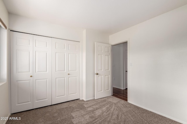 unfurnished bedroom featuring carpet, a closet, and baseboards