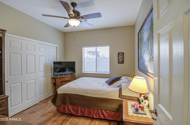 bedroom featuring hardwood / wood-style flooring, ceiling fan, and a closet