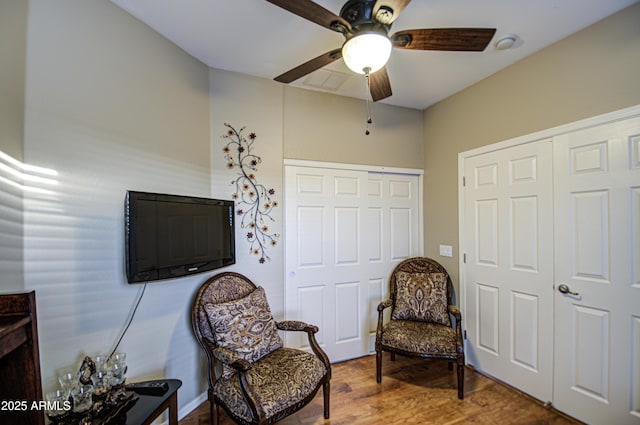 sitting room with hardwood / wood-style floors and ceiling fan