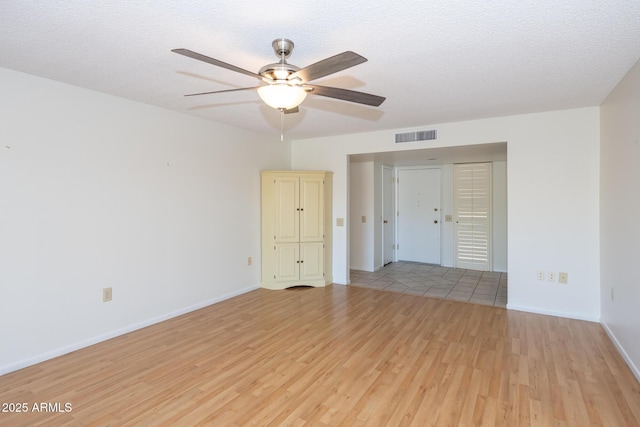 unfurnished room featuring a textured ceiling, light hardwood / wood-style floors, and ceiling fan