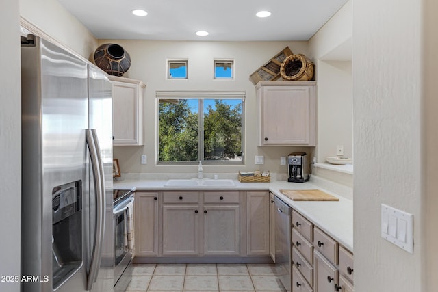 kitchen featuring light countertops, light tile patterned floors, recessed lighting, appliances with stainless steel finishes, and a sink