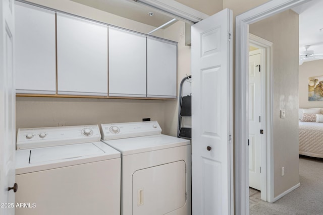 clothes washing area featuring baseboards, light colored carpet, washer and dryer, cabinet space, and a ceiling fan