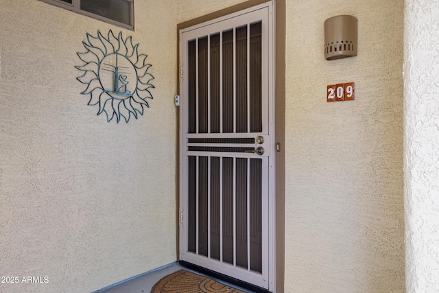 entrance to property featuring stucco siding