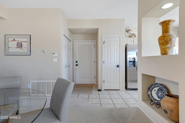 foyer entrance with light tile patterned floors and visible vents