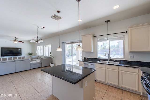 kitchen featuring light tile patterned floors, sink, stainless steel appliances, a center island, and ceiling fan with notable chandelier