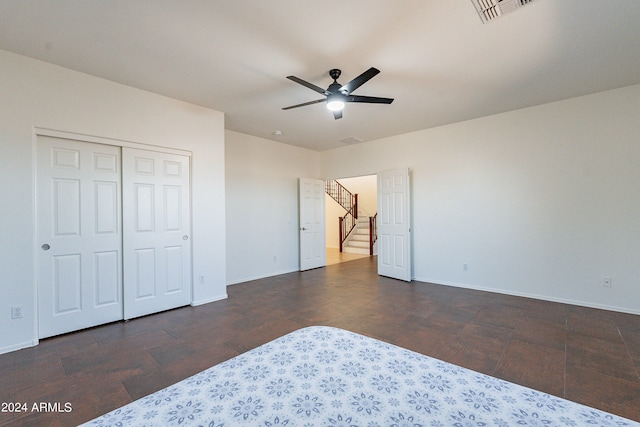 unfurnished bedroom featuring ceiling fan, a closet, and dark hardwood / wood-style flooring