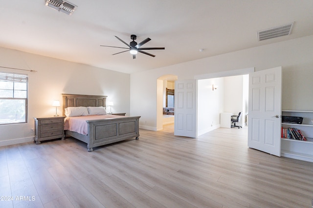 bedroom featuring light hardwood / wood-style floors, ensuite bath, and ceiling fan