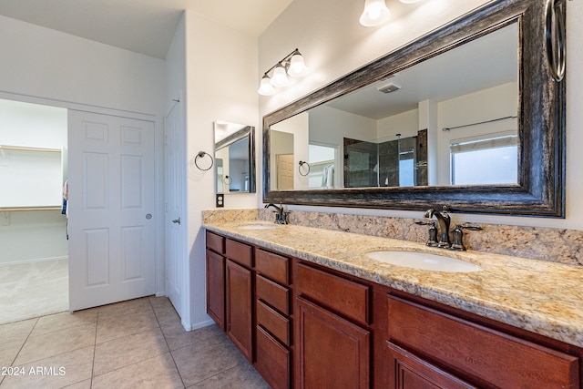 bathroom featuring tile patterned flooring, a shower with shower door, and vanity