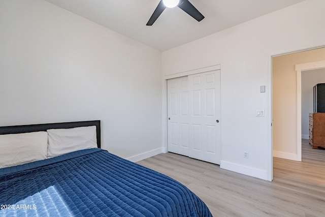 unfurnished bedroom featuring ceiling fan, light hardwood / wood-style flooring, and a closet